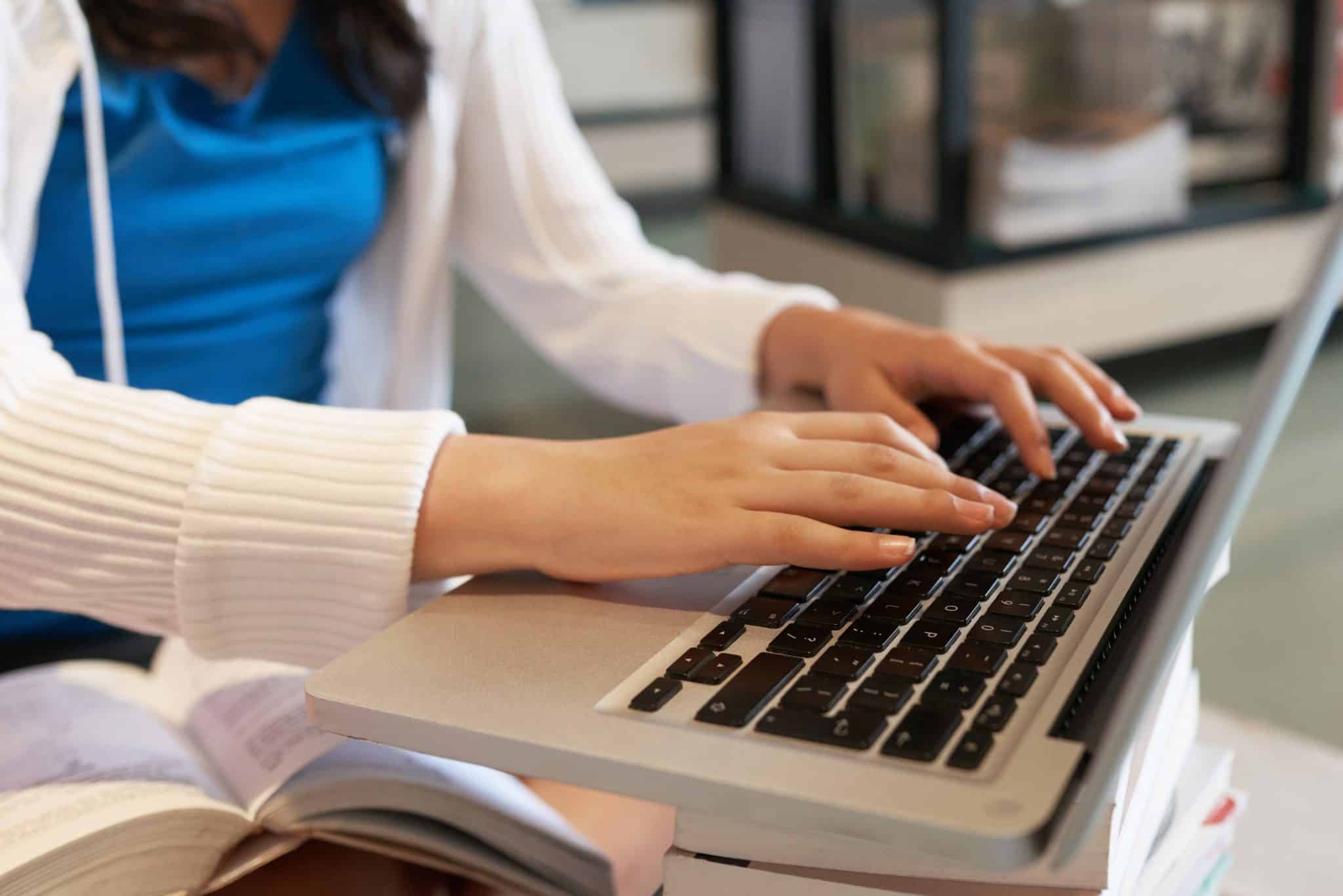 Woman typing on a laptop computer.