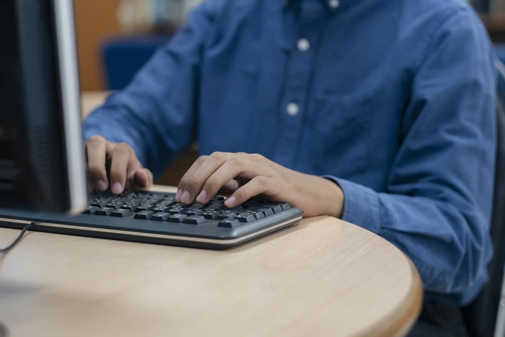Person typing on keyboard.