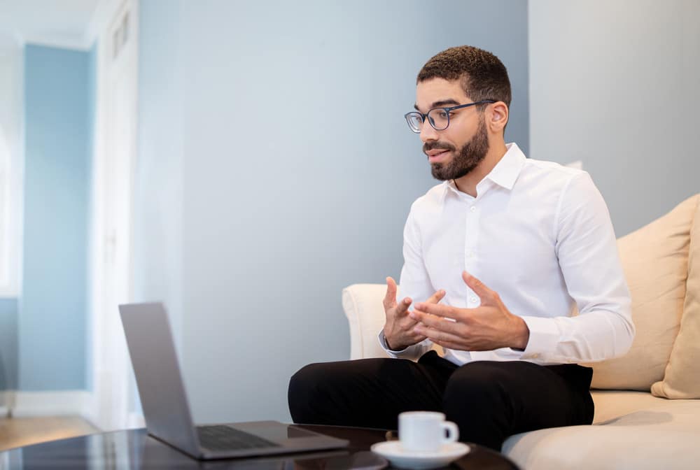 Man participating in virtual interview on laptop.